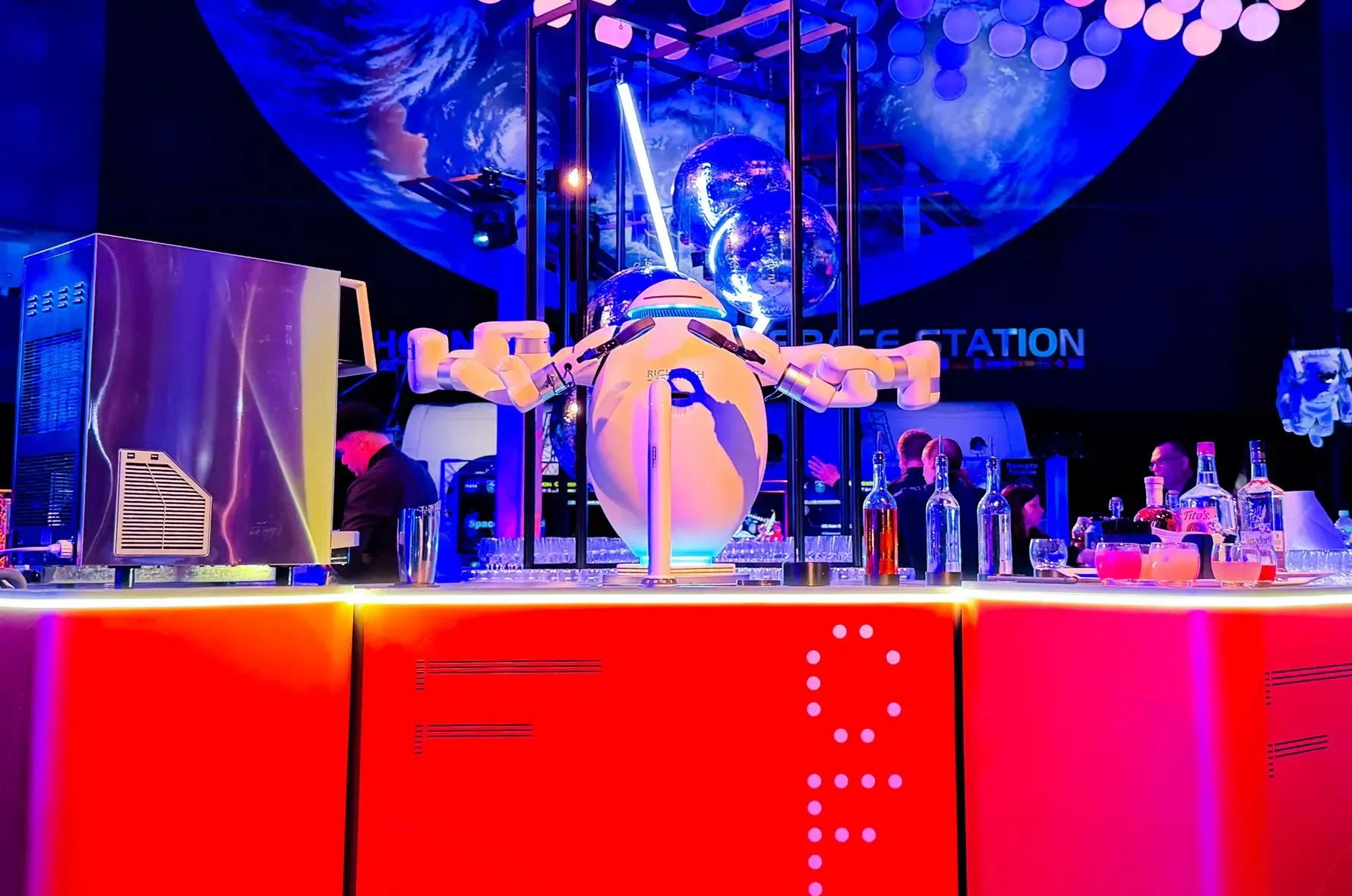 Richtech ADAM dual-arm robot mixing drinks at a bar